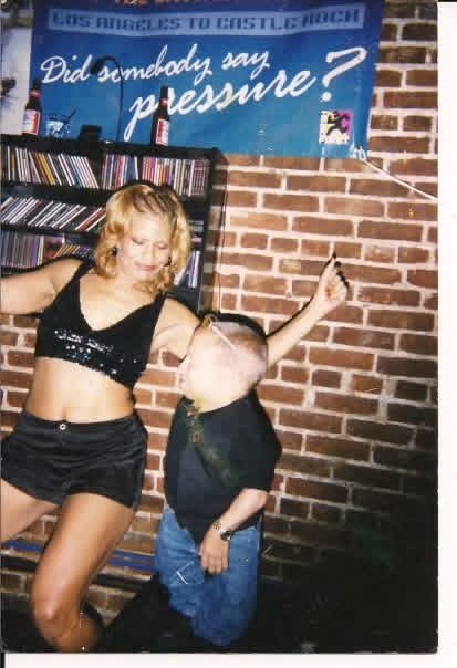 Dancer performing beside the CD shelves and brick walls inside Kane